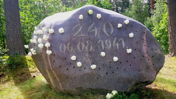Мемориальный камень в лесу у бывшей Светской мельницы на месте расстрела - большой ледниковый гранитный валун с цифрой 240 и датой казни - Sputnik Латвия