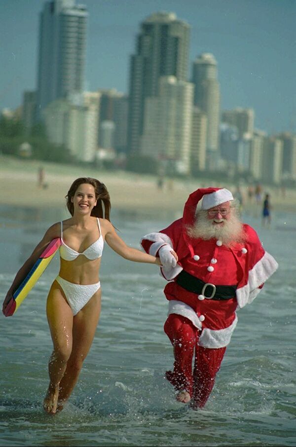 Санта-Клаус и девушка в бикини на пляже в Австралии - Sputnik Latvija