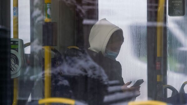 Женщина в маске в общественном транспорте в Риге - Sputnik Latvija