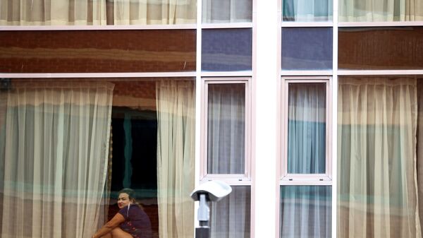Женщина смотрит из окна отеля Radisson Blu в аэропорту Хитроу, Лондон, Великобритания - Sputnik Латвия