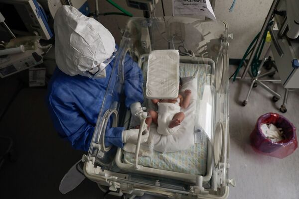 Medicīnas māsa ar koronavīrusu inficētu jaundzimušo dzemdību namā Tolukā, Meksikā - Sputnik Latvija