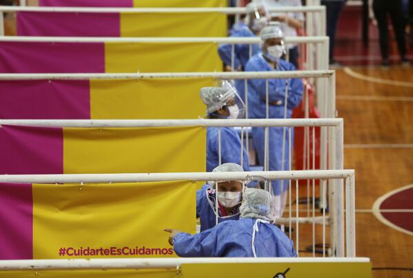 Medicīnas darbinieki vakcinācijai izmanto Krievijas preparātu Sputnik V stadiona River Plate basketbola laukumā Buenosairesā, Argentīnā - Sputnik Latvija