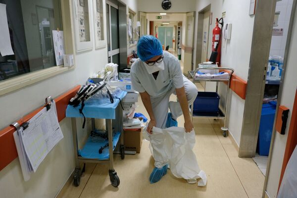 Medicīnas māsa pirms koronavīrusa pacientu palātas apmeklējuma slimnīcā Lisabonā, Portugālē - Sputnik Latvija