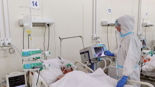 Медсестра у пациента в реанимационном блоке во временном госпитале для больных COVID-19 - Sputnik Латвия