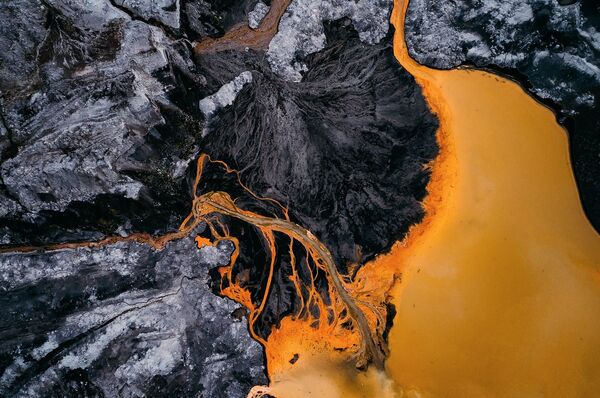 Abstraktā ainava ir ogļu ieguves sekas. Iegūstot brūnogles, minerāli saskaras ar skābekli un ūdeni. Rezultātā veidojas hidroksīds un dzelzs sulfāts, tāpēc veidojas ūdens piesārņojums - Sputnik Latvija