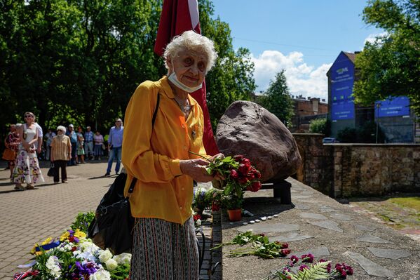 Женщина возлагает цветы к мемориалу Большой хоральной синагоги в День памяти геноцида еврейского народа в Латвии. - Sputnik Латвия