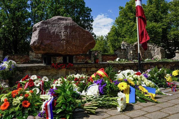 Они возлагают к памятнику цветы и венки. - Sputnik Латвия