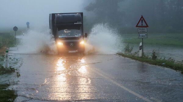 Автомобиль едет по дороге, пострадавшей от наводнения, Германия - Sputnik Latvija