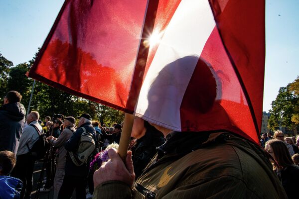 Vīrietis ar Latvijas karogu protesta akcijā pie Brīvības pieminekļa - Sputnik Latvija