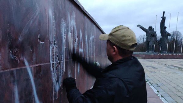 Общественник смывает надпись оккупанты с памятника Освободителям - Sputnik Латвия