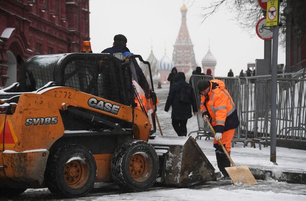 Сотрудники коммунальной службы чистят тротуар от снега в Москве - Sputnik Латвия