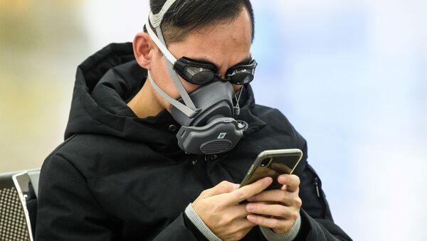 Пассажир в очках для плавания и маске на железнодорожной станции в Гонконге - Sputnik Latvija