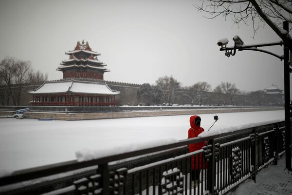 Туристов и местных жителей на улицах почти нет. Девушка в маске во время селфи у Запретного города в Пекине  - Sputnik Латвия