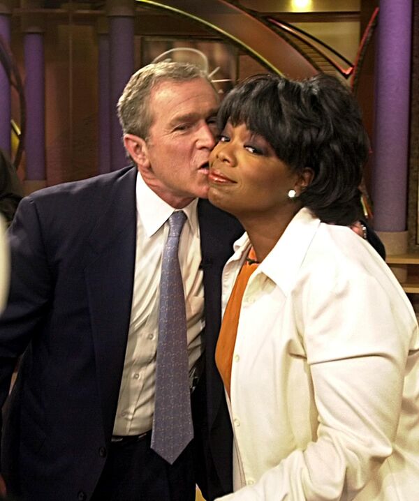 Кандидат в президенты США Джордж Буш-младший целует Опру Уинфри после выступления на ее шоу 19 сентября 2000 года в Чикаго - Sputnik Латвия