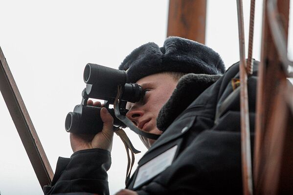 Сотрудник милиции наблюдает в бинокль за обстановкой в зоне - Sputnik Латвия