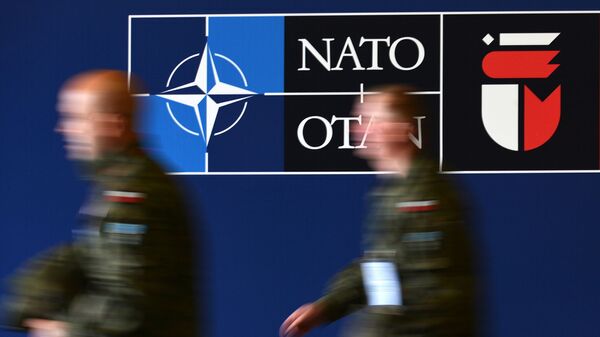 Мужчины у баннера саммита НАТО на Национальном стадионе в Варшаве - Sputnik Латвия