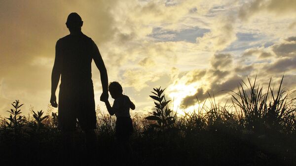 Pieaugušais un bērns saules rietā. Foto no arhīva - Sputnik Latvija