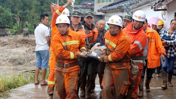 Спасатели транспортируют пострадавшего при сходе селя в провинции Сычуань в Китае, 8 августа 2017 - Sputnik Латвия