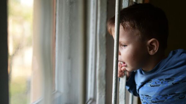 Воспитанник детского дома смотрит в окно - Sputnik Латвия