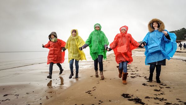 Девушки в дождевиках на пляже Юрмалы - Sputnik Latvija