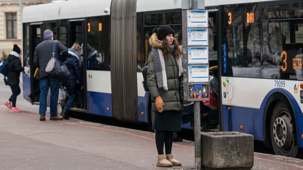 Meitene pilsētas transporta pieturā Rīgā - Sputnik Latvija