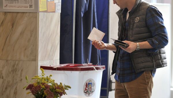 Житель города Риги на одном из избирательных участков во время голосования на парламентских выборах в Латвии. - Sputnik Латвия