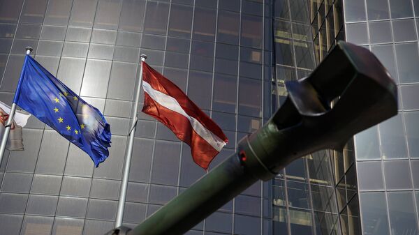 Дуло самоходной гаубицы на фоне флагов Латвии и Евросоюза, иллюстративное фото - Sputnik Латвия